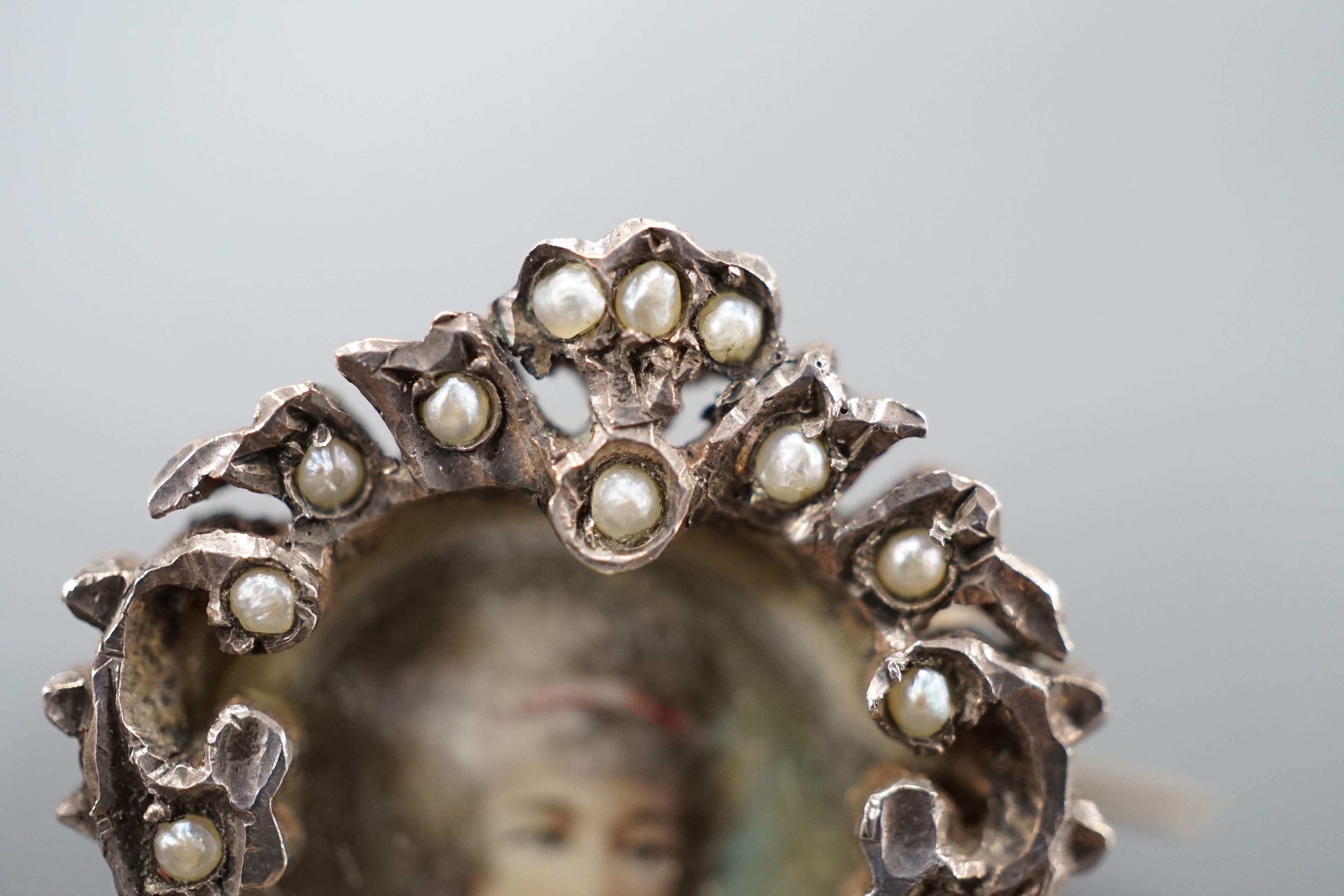 A Victorian yellow and white metal and paste set oval miniature brooch, 41mm and a small circular seed pearl set miniature brooch.